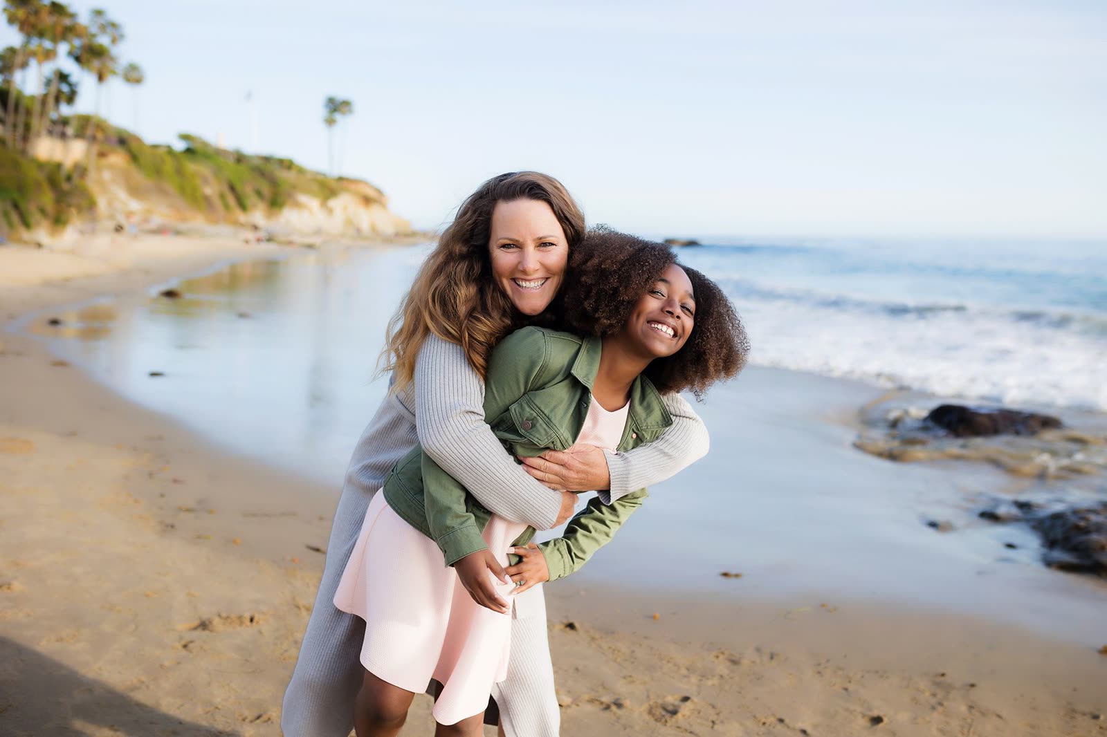 A mother with her children on the shoreline at sunset